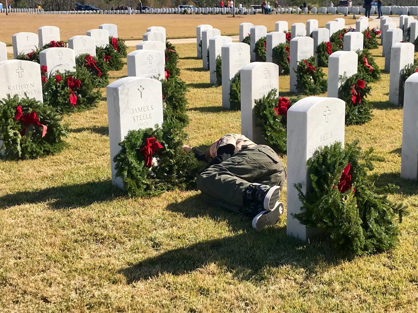 All tuckered out.... Conner Steele taking a nap by his Grandfather's stone after placing wreaths throughout Section 7 and 8.