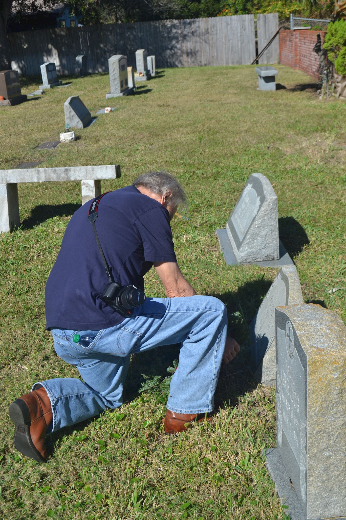 Gentleman putting a wreath at a soldiers grave.