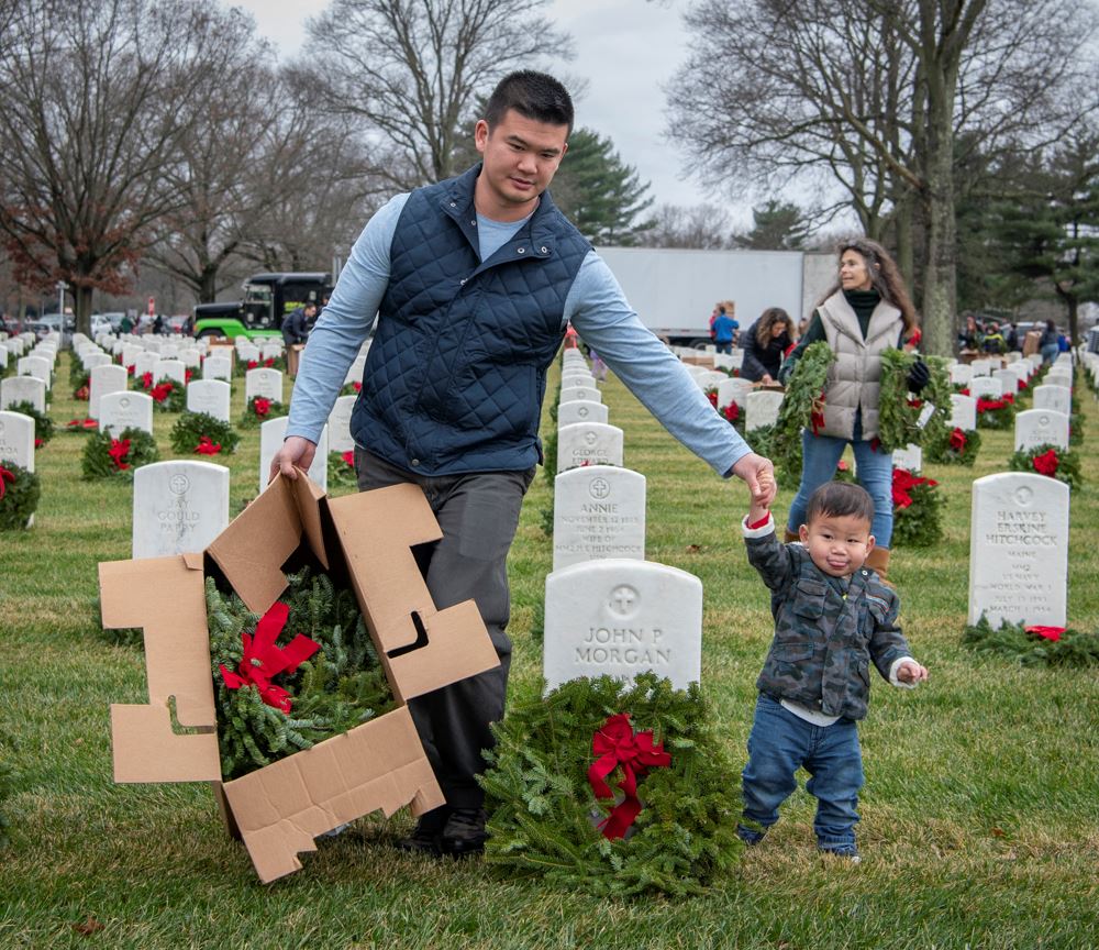 A Father and Son walk through the cemetery with wreaths to honor our veterans.