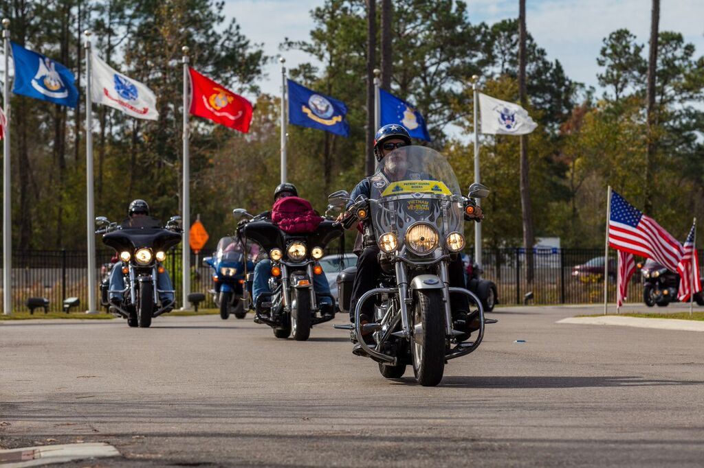 Patriot Guard Riders carrying wreaths into the cemetery