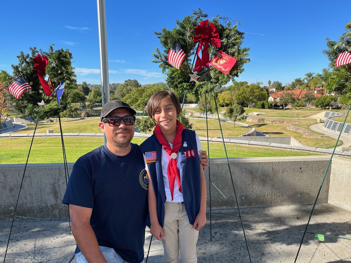 Sofia standing in front of the Marine Corps wreath with her dad.