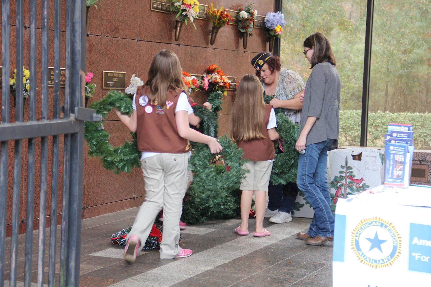 Several Brownie (Girls Scouts) getting wreaths to lay from American Legion Post #113 Commander