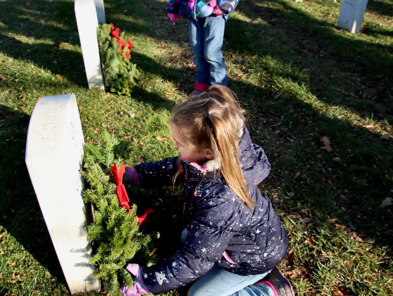 Child places wreath - December 2022