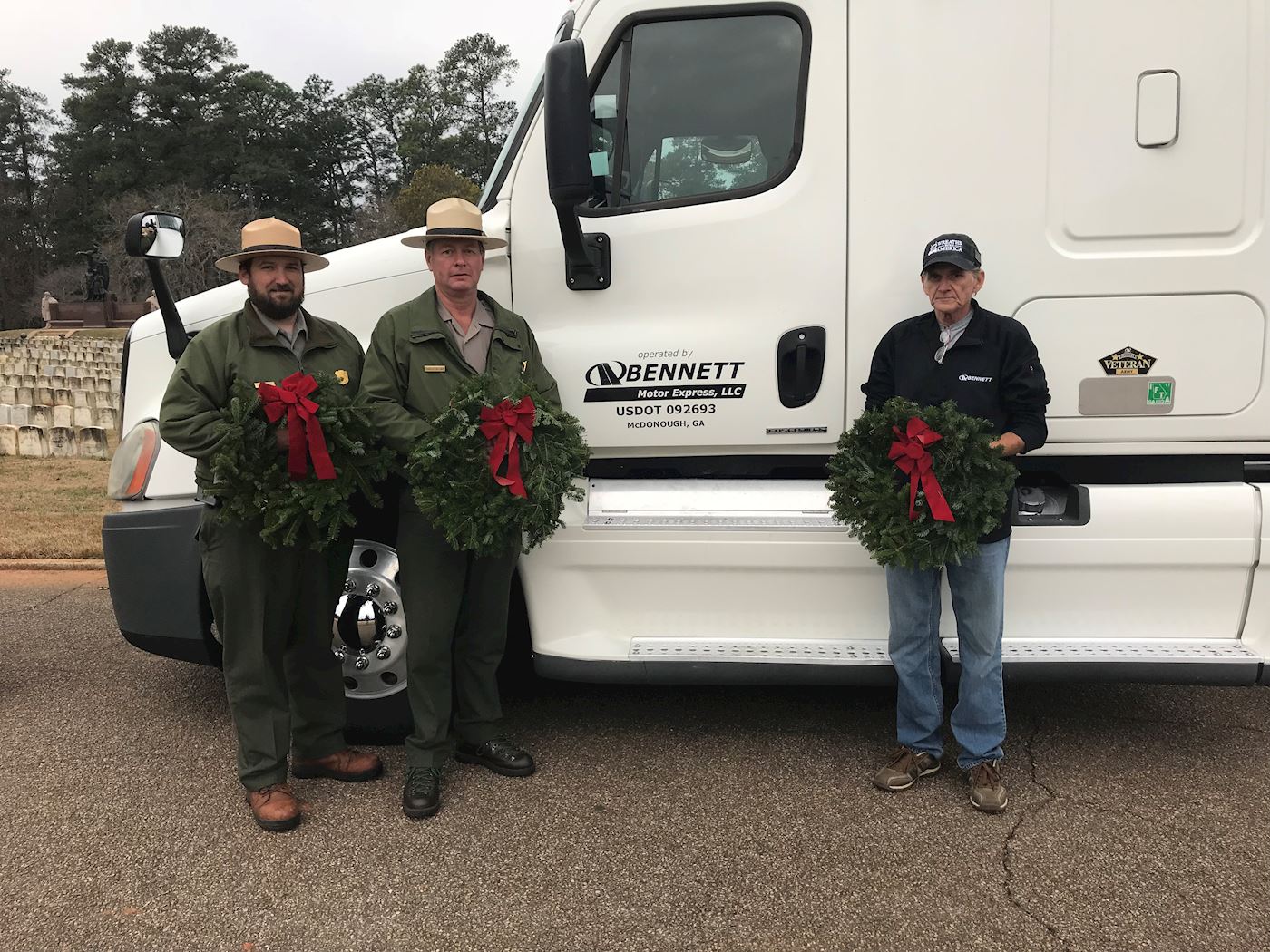 Bennett is proud to honor our fallen service members from all eras by participating for the first time in Wreaths Across America. Marty Roberts, a Bennett Motor Express owner operator who served 9 years in the Army, picked up a trailer load of wreaths at the National Headquarters in Harrington, Maine on Monday. This morning, Marty arrived at the Andersonville National Cemetery in Georgia to deliver over 3,100 wreaths that will be presented tomorrow on grave sites of fallen veterans there. This ceremony is one of 1,200 that will take place including the largest at Arlington National Cemetery. Joining Marty, was Lee Gentry EVP of Bennett. Both said that they are humbled and honored to take part in the efforts.