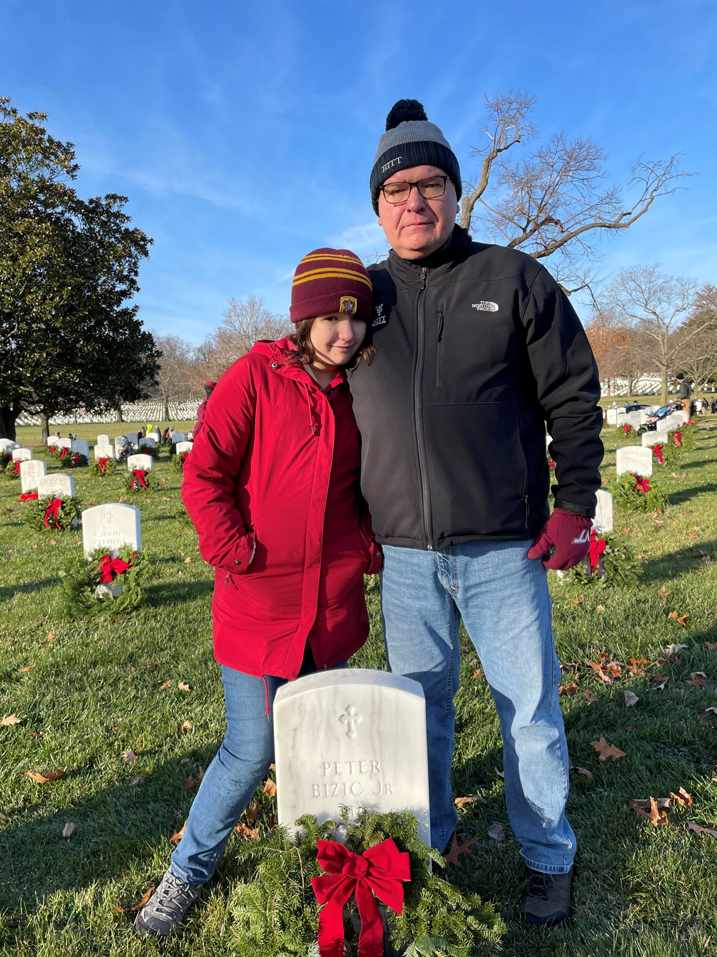 HITT Employee Peter Bizic places a wreath on his father's grave with his daughter Amelia