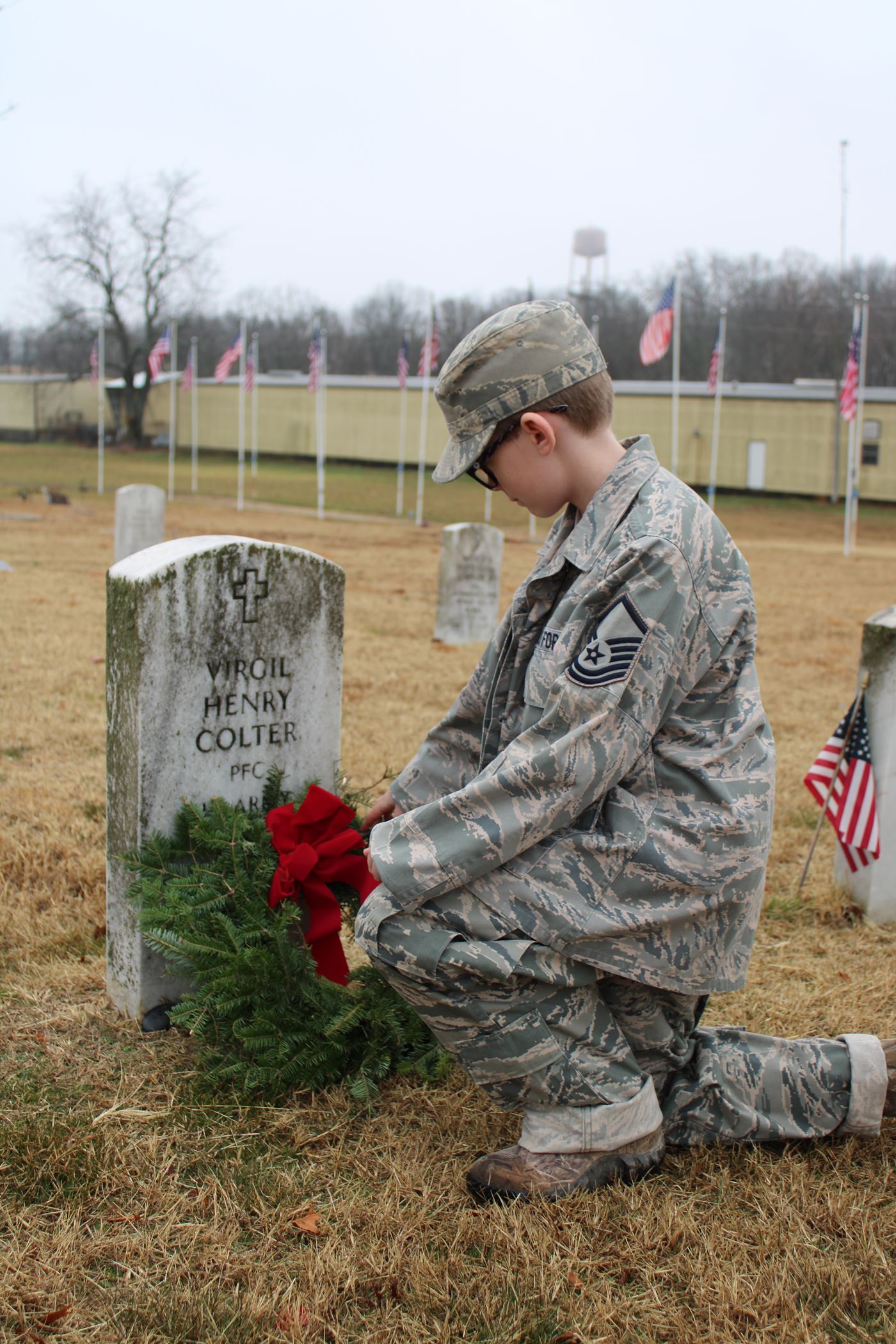 A young boy Remembers and Honors his grandfather by dressing in his uniform and placing a wreath on his grandfather's grave<br>