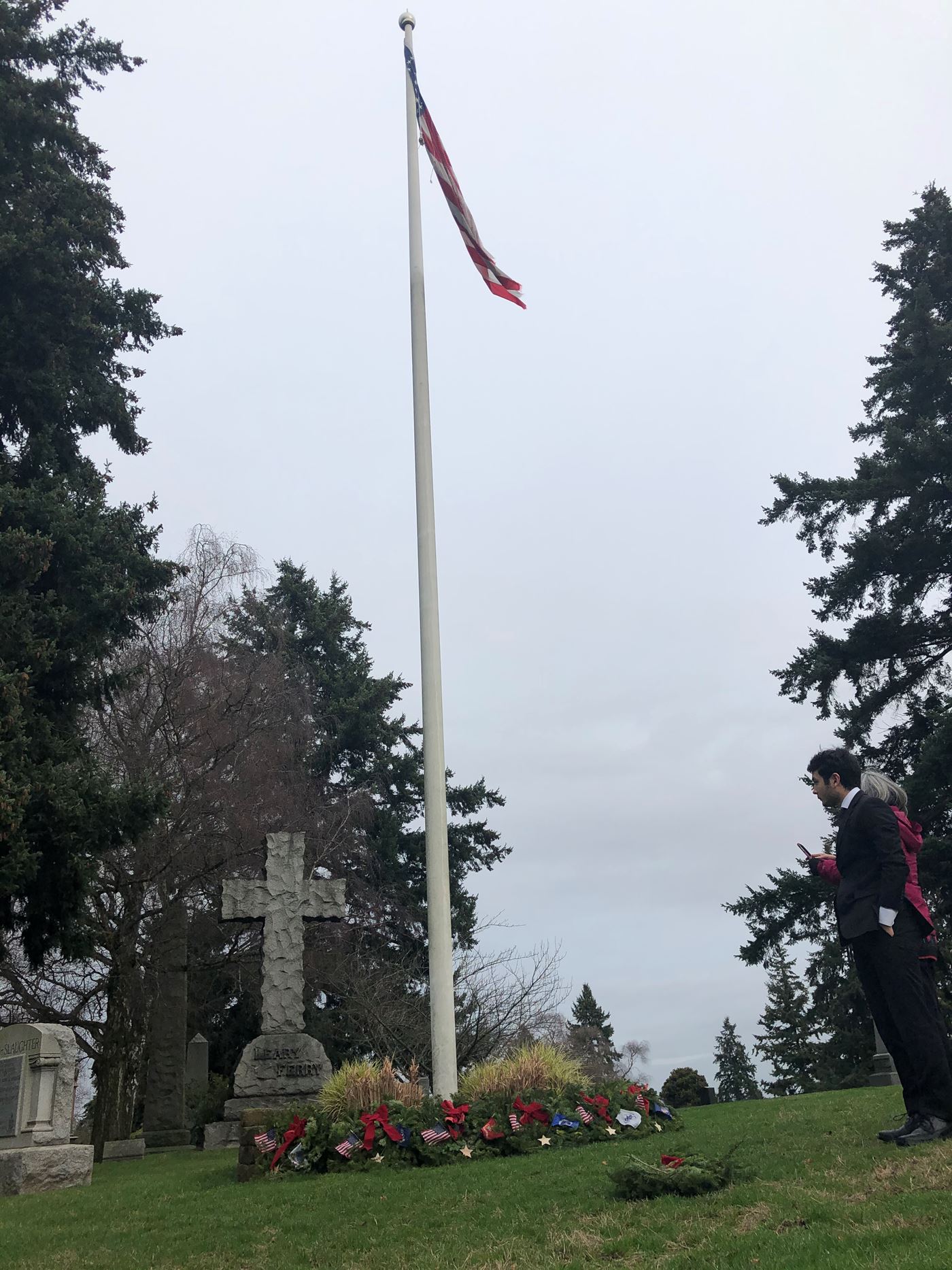Flag pole at Lake View Cemetery with ceremonial wreaths at base.