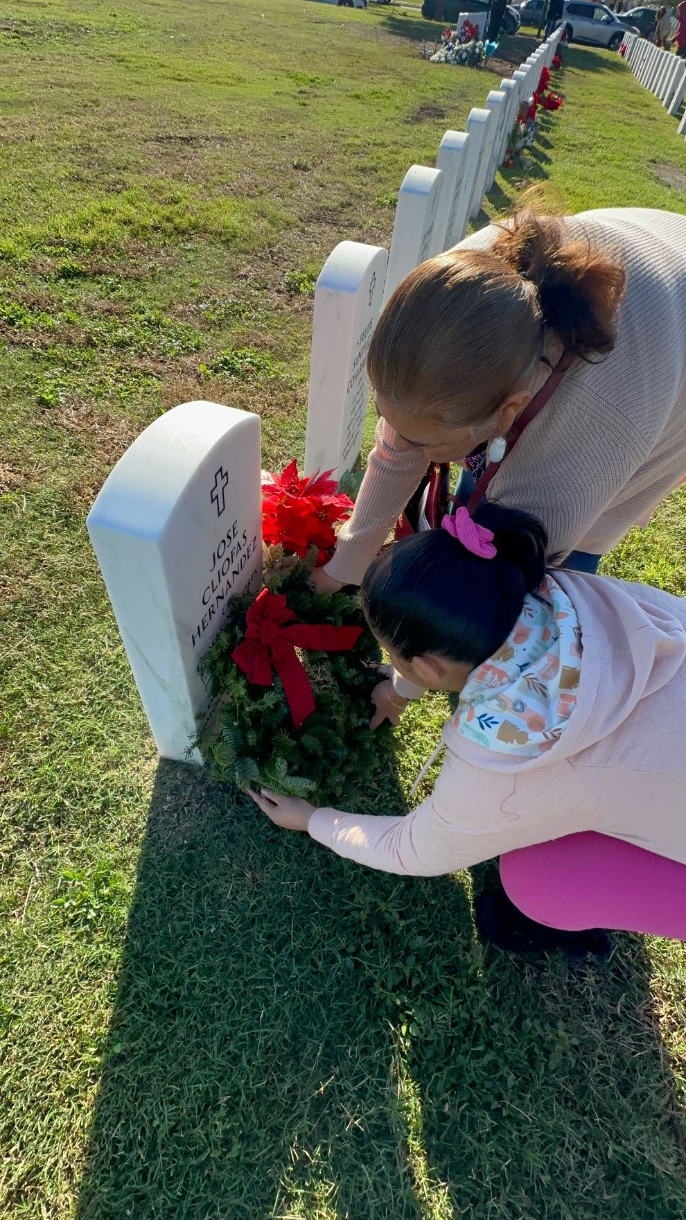 Mama and Ava placing a wreath for Pops