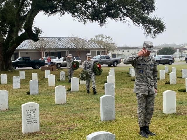 A moment of solemn respect as a cadet salutes the resting place of a fallen hero.