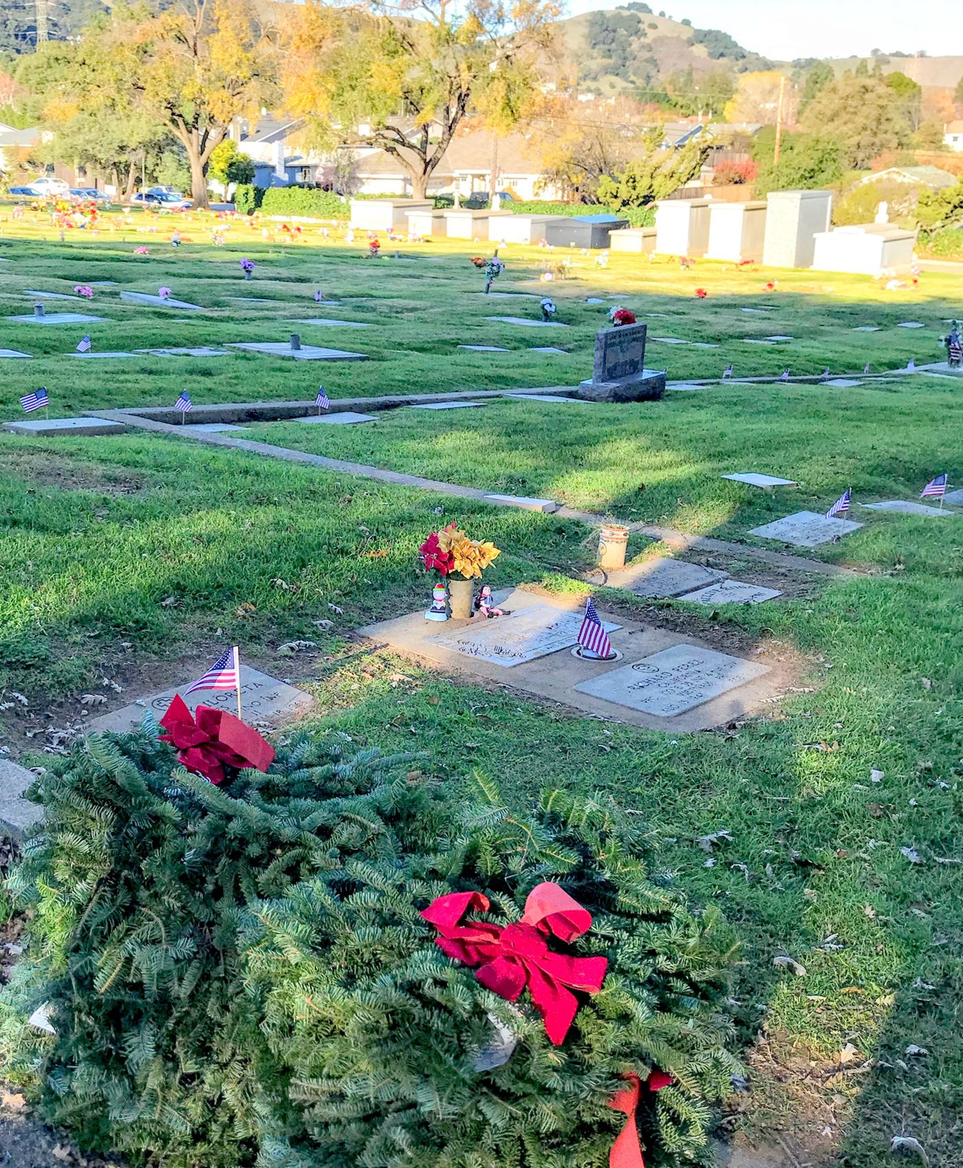 American flags are placed on the graves first, then the wreaths are stacked along the end of the rows.  After the opening ceremony and dedications, the families of the veterans are first to lay their wreaths and then the whole community joins in.   
Mt. Hope Cemetery, Morgan Hill, California