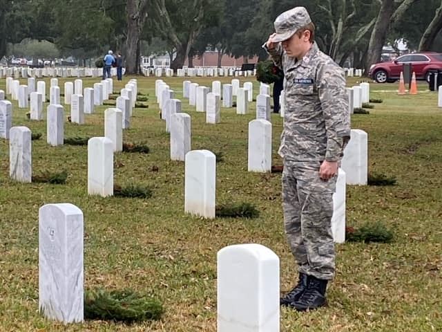 A cadet pauses to reflect, honoring the memory of a veteran.