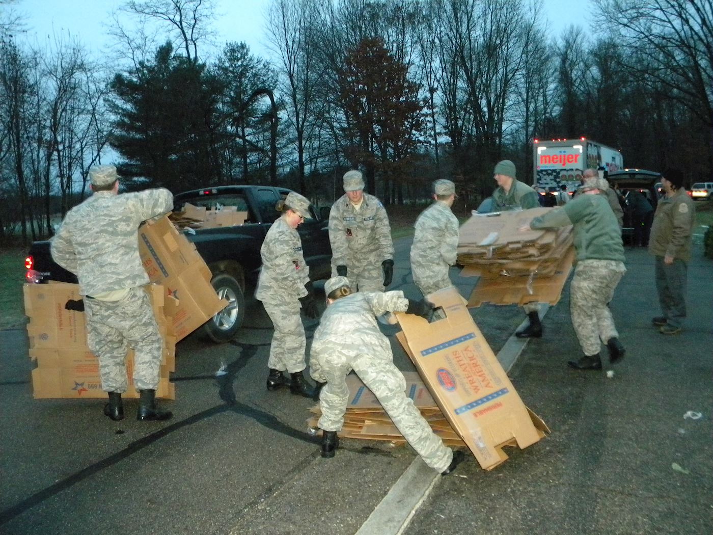 Civil Air Patrol cadets work to clear the area of boxes before volunteers arrive for the ceremony.