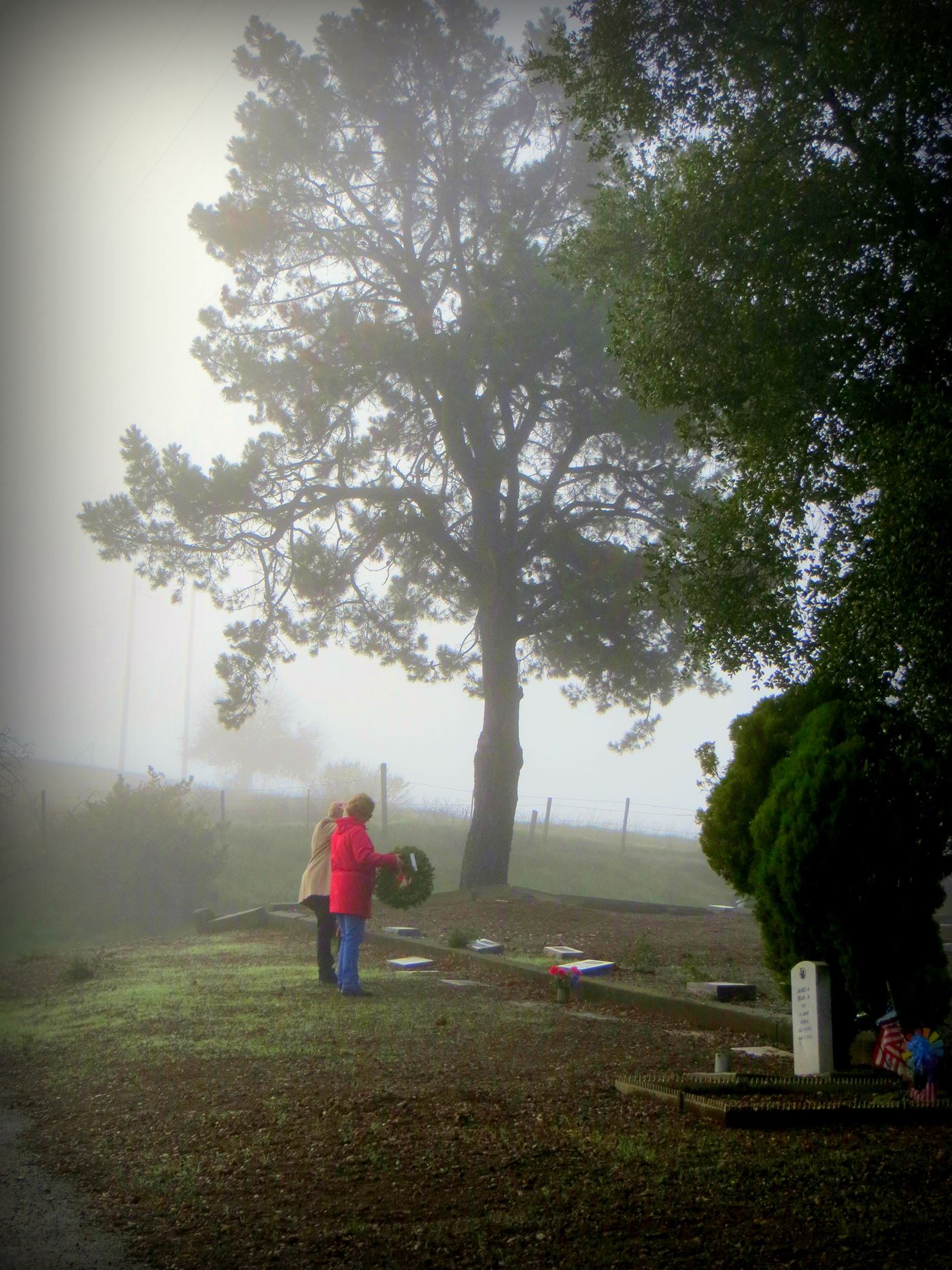 After the opening ceremony, the families with veterans in the cemetery are first the lay wreaths, then the group lays all the rest.  Gabilan DAR member Kris Hernandez lays a wreath with her cousin Jackie Berryhill