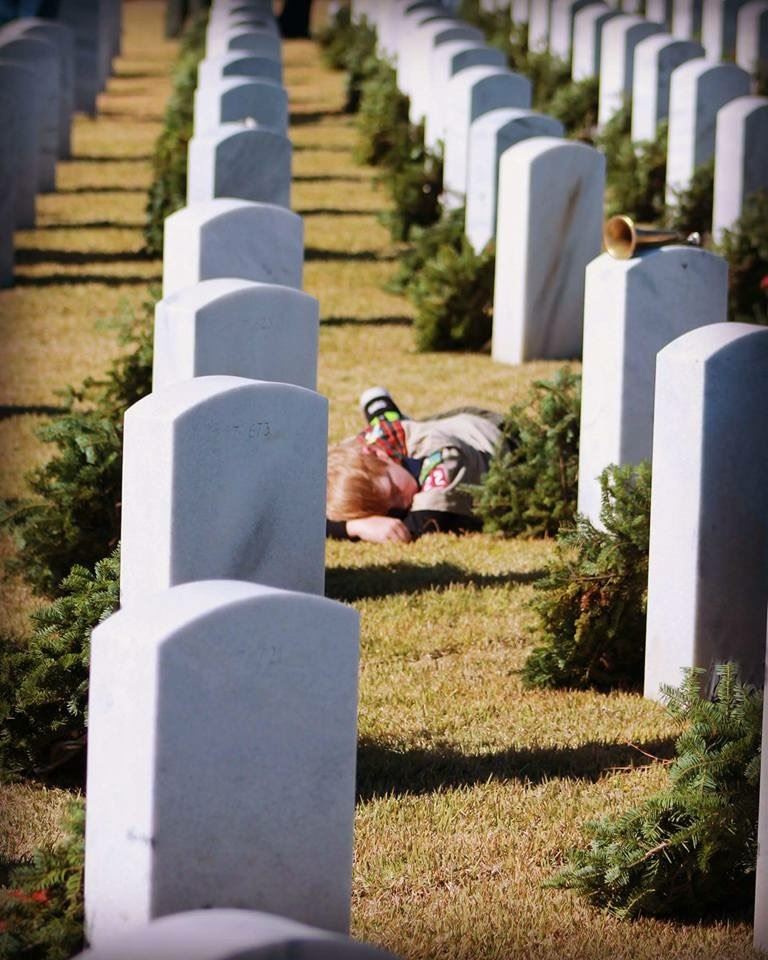 All tuckered out.... Conner Steele taking a nap by his Grandfather's stone after placing wreaths throughout Section 7 and 8.