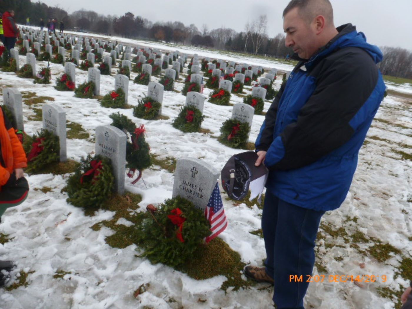 A Troop7 leader offers prayers at the headstone of a loved one in Saratoga National Cemetery in Dec 2019.