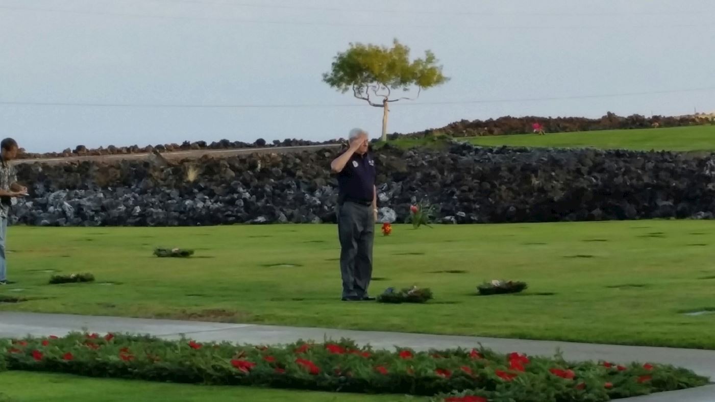 Major Dunne, Retired USAF, salutes the grave of an Airman.