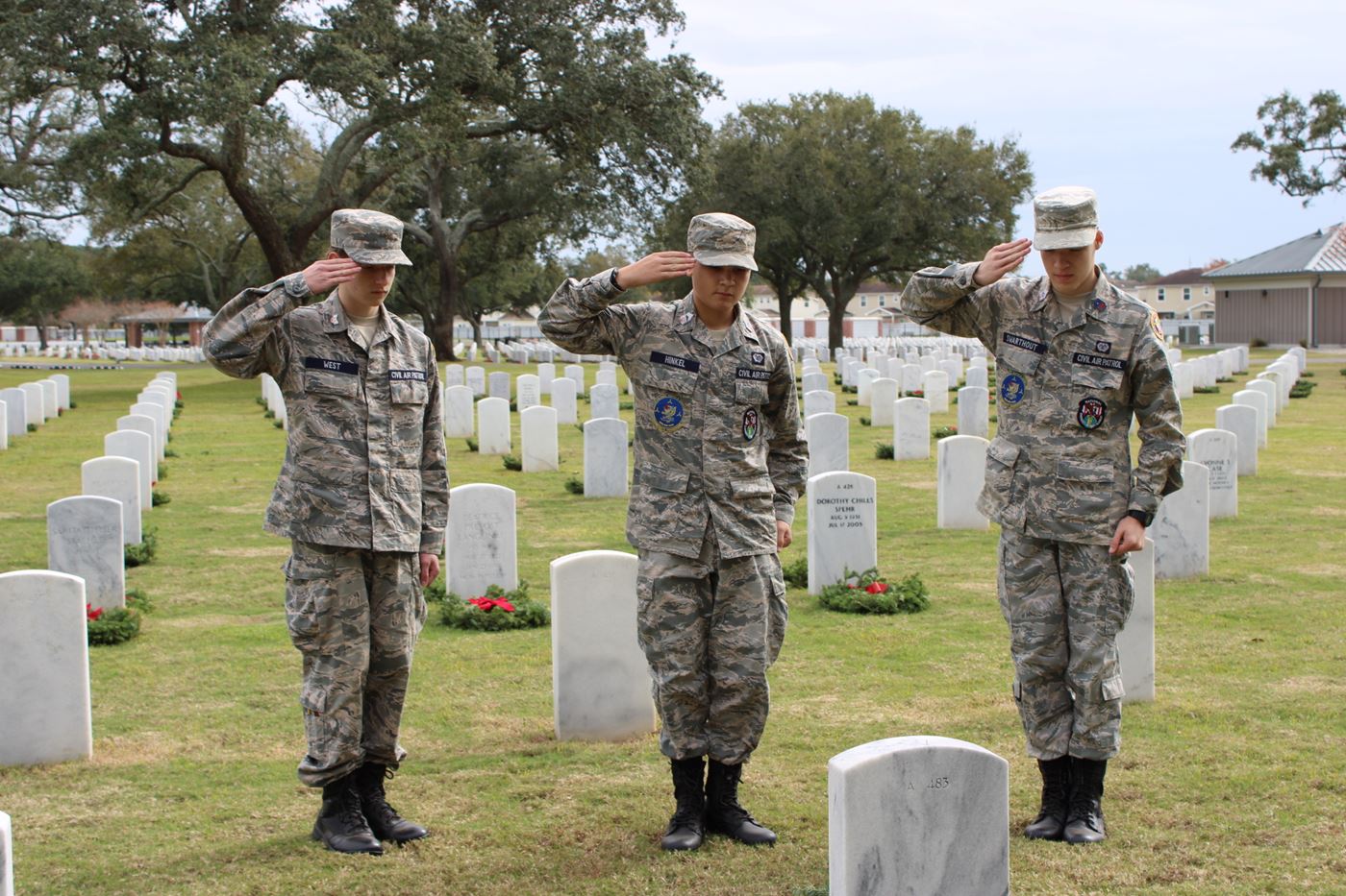 Cadets West, Hinkle, and Swarthout stand in solemn salute to honor the brave men and women who served our nation.