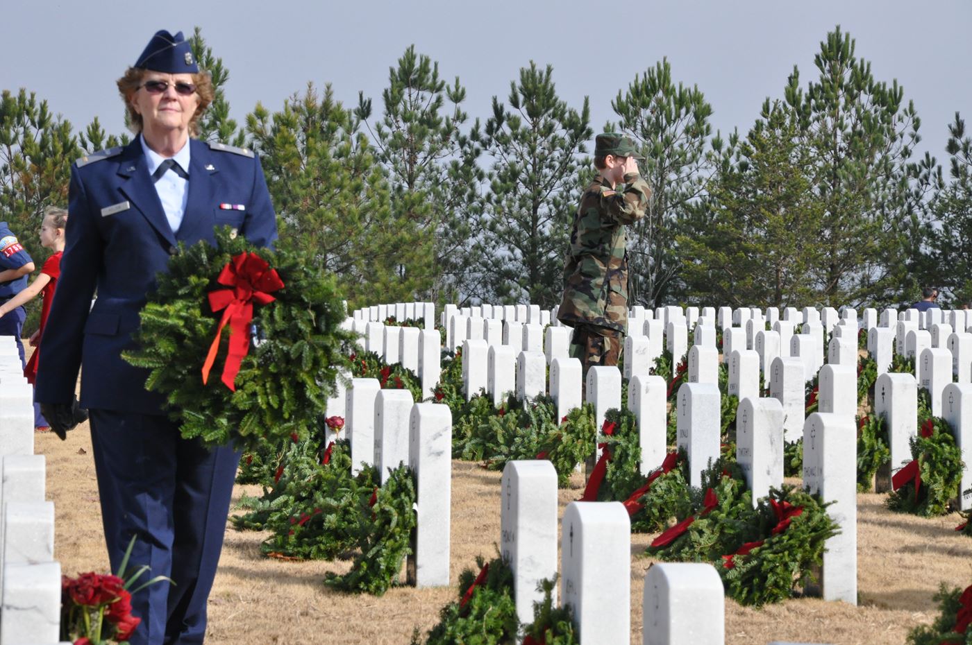 CAP Lt delivers a wreath while a cadet salutes an honoree.