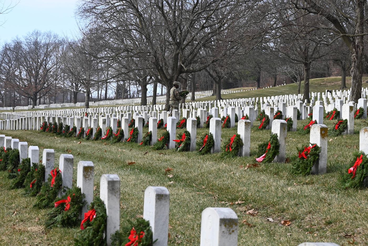 A Fort Leavenworth Soldier works alongside volunteers to lay wreaths on graves during Wreaths Across America Day, Dec. 19, 2020.