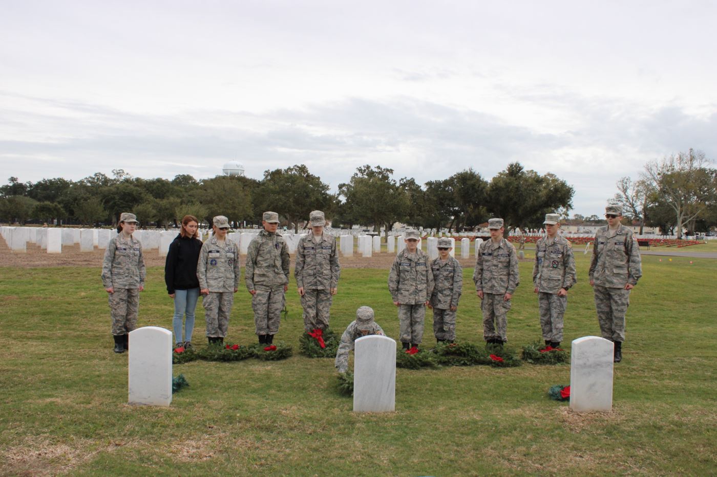 Cadets stand in silent tribute as they honor a fallen veteran by laying a wreath, continuing the legacy of service and remembrance