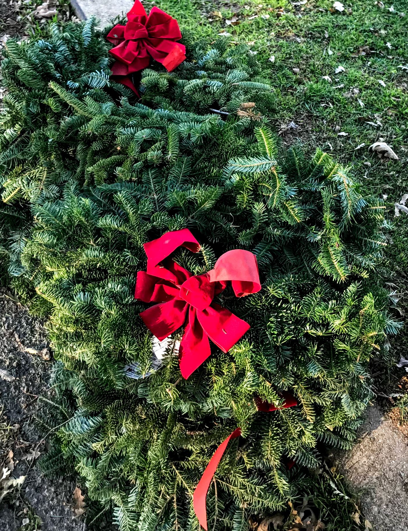 Early in the morning, an American flag is placed on each veteran gravesite, then the wreaths are stacked at the ends of the rows for everyone to place throughout the cemetery.