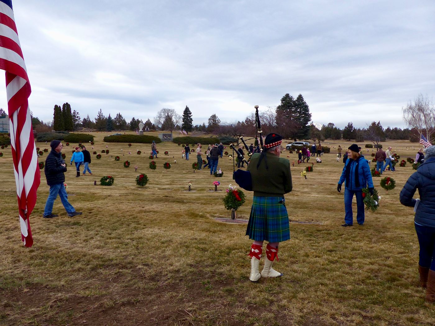 Steve Allely at bagpipers while wreaths are being laid.