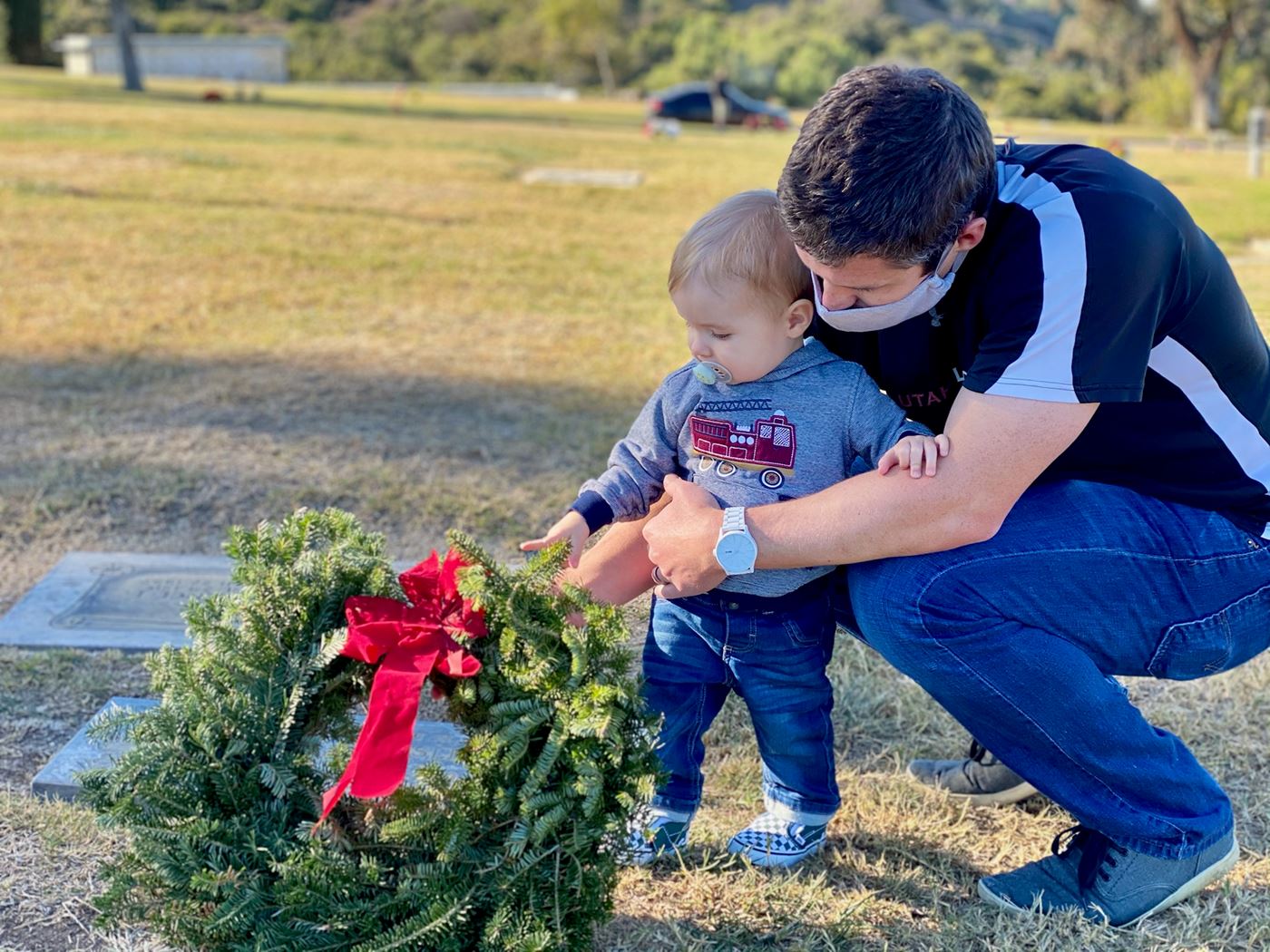 1 yr old placing wreath on great grandpa's grave