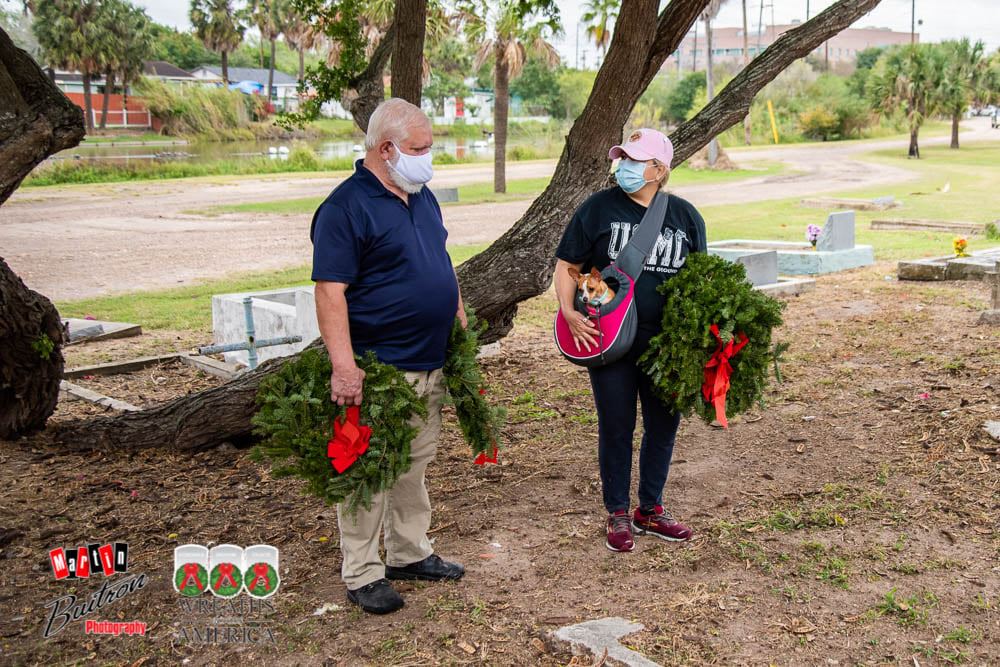 Ms Laura Serna Marquez, USMC veteran and coordinator of WAA Brownsville, explains and demonstrates to U.S. Navy veteran Mr. Dave Parsons the proper way to lay the wreaths.